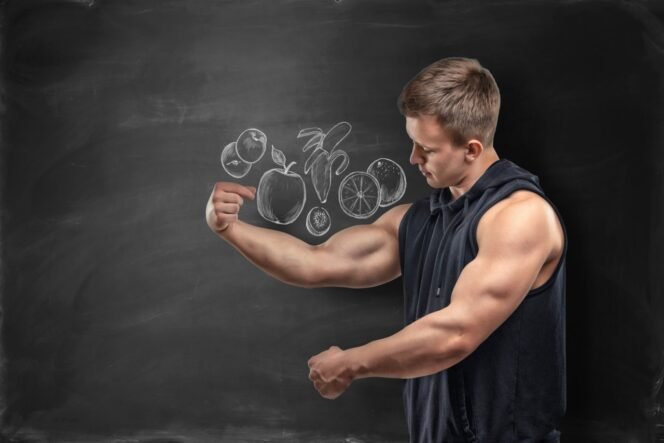 
 Fruits pictured on a black background and a fitness man showing his bicep under the picture. Proper nutrition. Gaining muscle mass. Keeping on a diet.