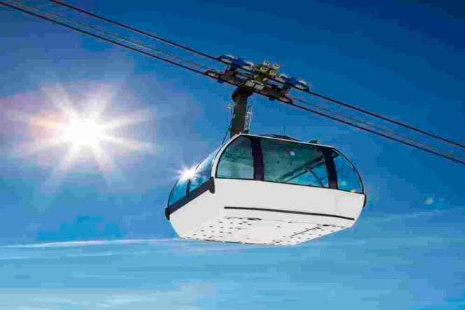 
 Cable car and sun in a mountain area